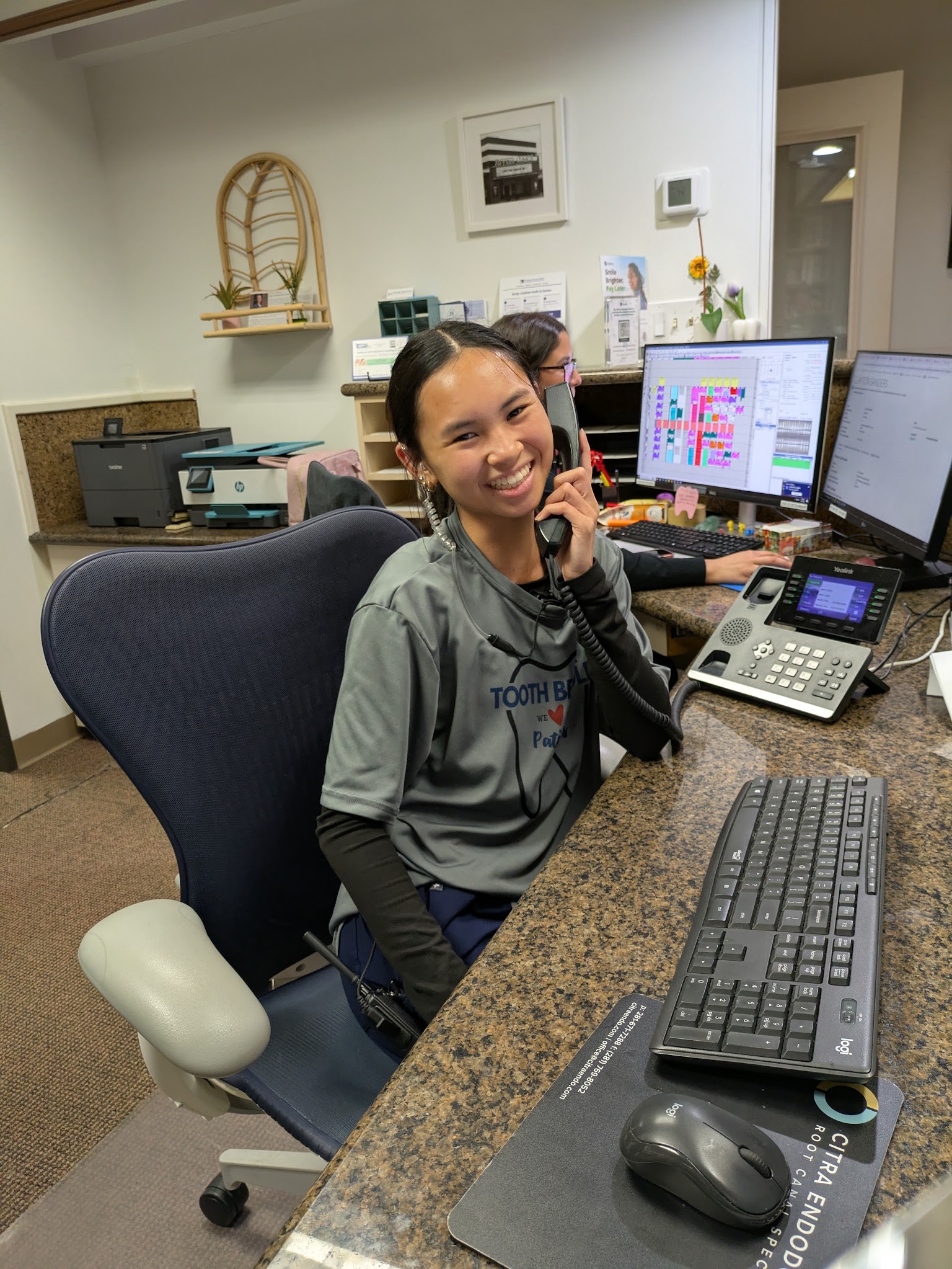The front desk laughing on a call with a patient