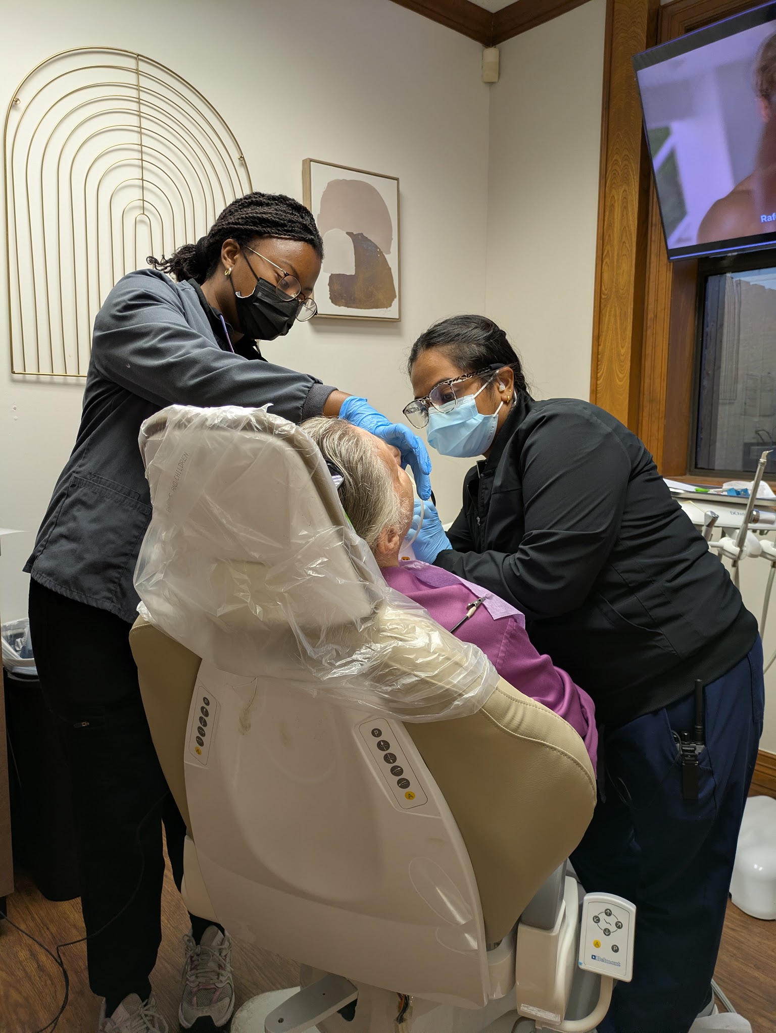 Two of the team with a patient in the chair