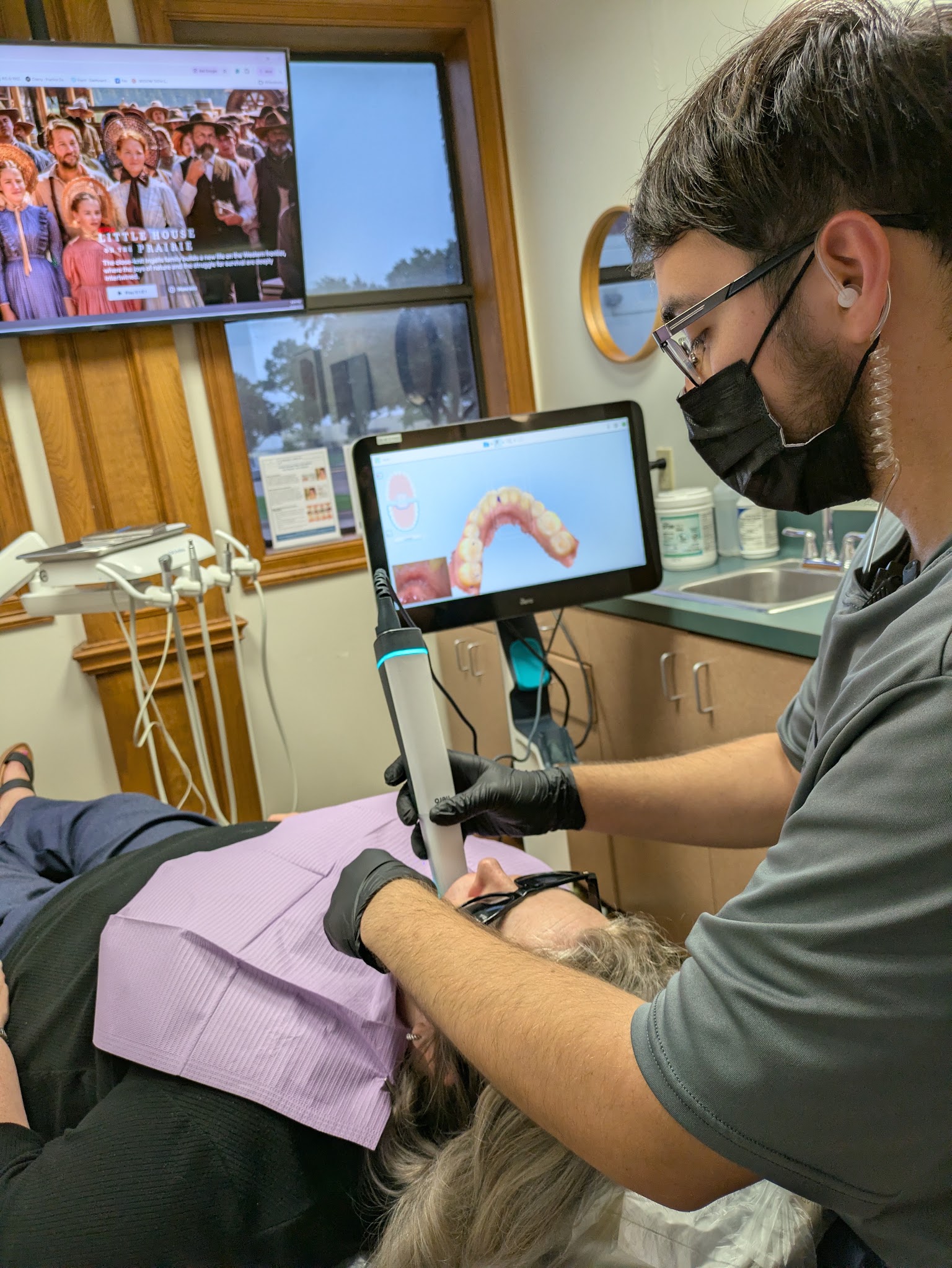The intraoral scanner showing a patient's teeth on the screen