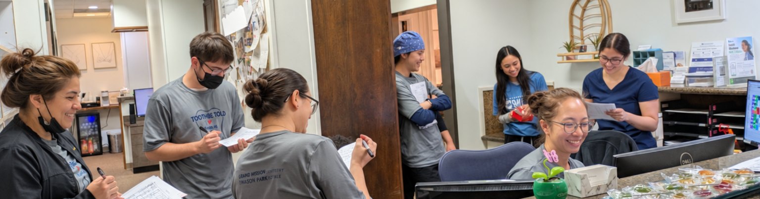 The team gathered at the front desk with clipboards, laughing before the day starts