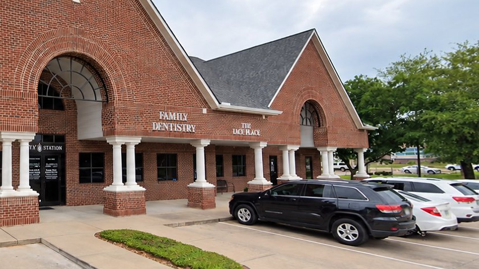 The brick building on Kingsland Boulevard with its arched entrance, covered walkway and parking at the door