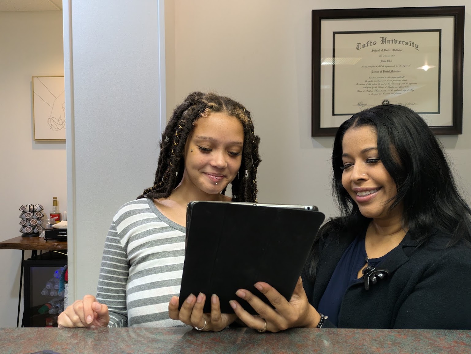 A mother and daughter at the front desk with the treatment plan