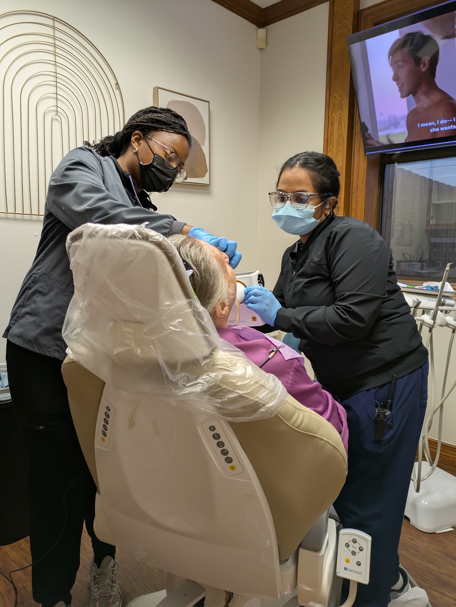 Two of the clinical team with an adult patient in the chair