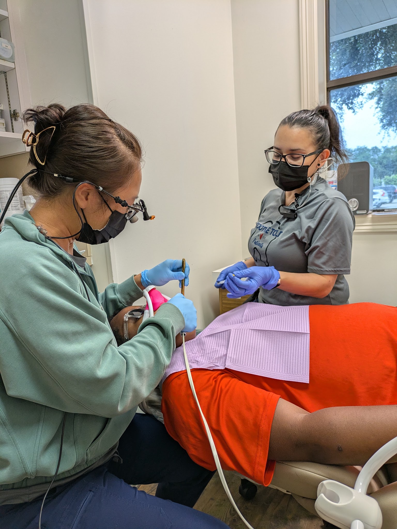 A hygienist working with an assistant