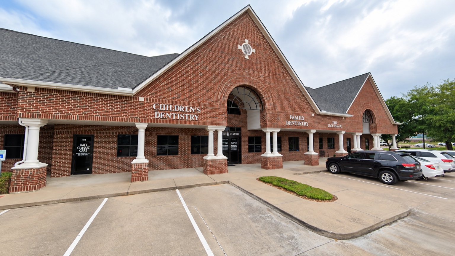 The brick building on Kingsland Boulevard with its arched entrance, covered walkway and parking at the door